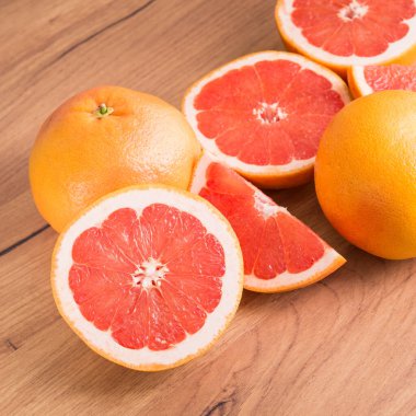 Mutfak ahşap masasında dilimlenmiş sulu greyfurt parçaları..
