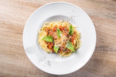 Tahta bir masada fesleğenli İtalyan spagetti bolonezi. en üstteki görünüm