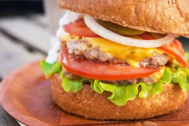 Lezzetli ve taze hamburgeri sığır eti ve domatesli, peynirli tabakta. sokak fast food geçmişi