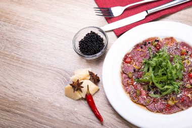 Biftek carpaccio roka ve ahşap masada siyah havyar. Üst Manzara. düz yat