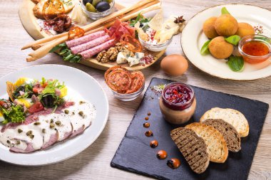 Salatalı bulaşıklar, arancini, ahşap bir masada kulübe tahtası. düz yatış, üst görünüm