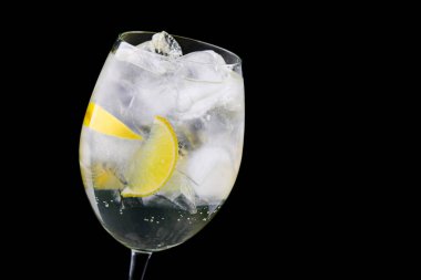 Siyah arka planda limon ve buzlu taze alkollü içecek.