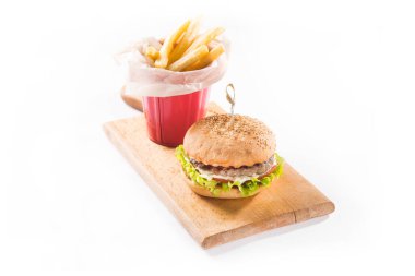 Arkaplanda izole edilmiş tahtanın üzerinde hamburger ve patates kızartması.