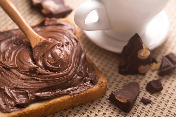 Çikolatalı ekmeğin tatlı kahvaltısı ve sabah masasında bir fincan kahve.