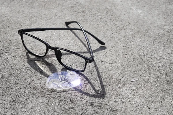 壊れた眼鏡がアスファルトの上に横たわっていた 道路上の不快な状況は — ストック写真