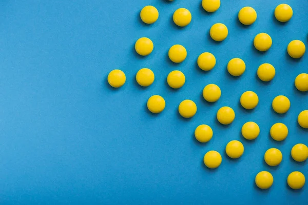 青い背景の薬黄色の丸薬 — ストック写真