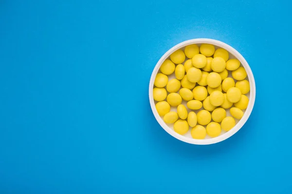 Medyczne Żółte Okrągłe Tabletki Niebieskim Tle Widok Góry — Zdjęcie stockowe