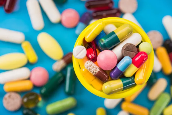 Many Colored Pills Capsules Yellow Container Blue Background Top View — Stock Photo, Image