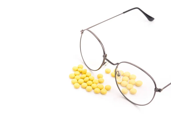Vision glasses and pills vitamins for improving the eyes. Isolated on a white background.