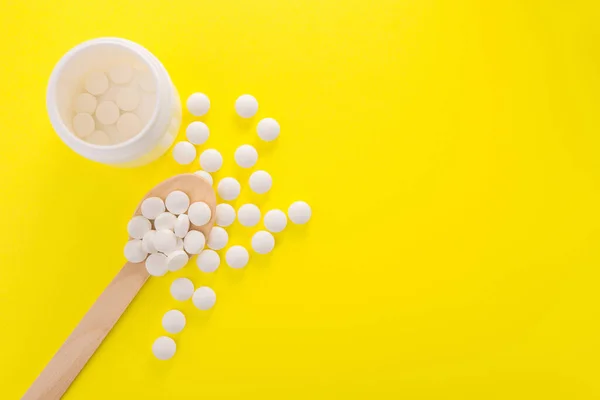 Białe Tabletki Medyczne Tabletki Drewnianej Łyżeczce Żółtym Tle Widok Góry — Zdjęcie stockowe