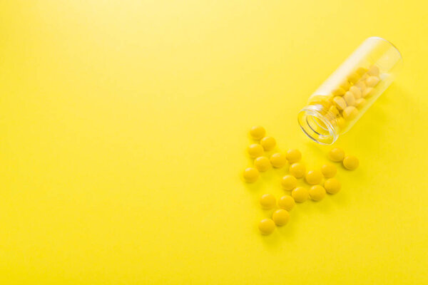 Concept of yellow pills on a background, bright minimalism.