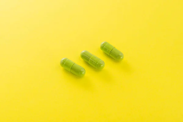 Three Green Capusle Yellow Background Bright Medical Photo — Stock Photo, Image