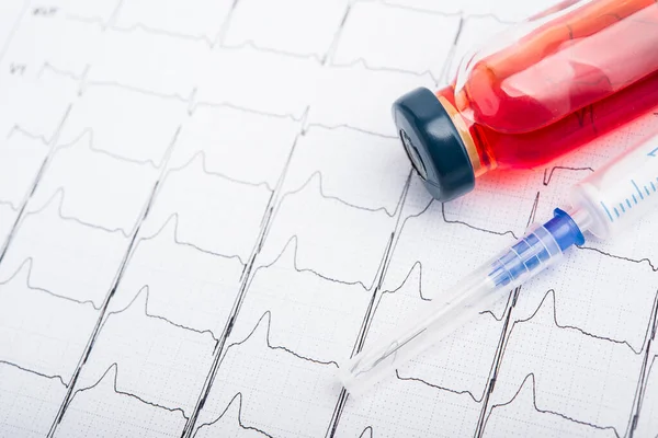 EKG sonuçları kağıt üzerinde ve kalp atışlarını düzeltmek için kırmızı enjeksiyon. Kalp krizi ya da yüksek tansiyon.