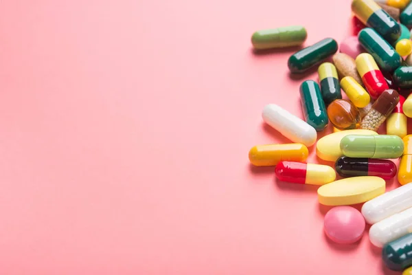 Renkli Haplar Kapsül Tabletler Pastel Pembe Arka Planda — Stok fotoğraf