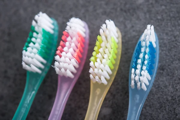 Cztery Kolorowe Szczoteczki Zębów Dla Rodziny Kamiennym Tle Łazience Higiena — Zdjęcie stockowe