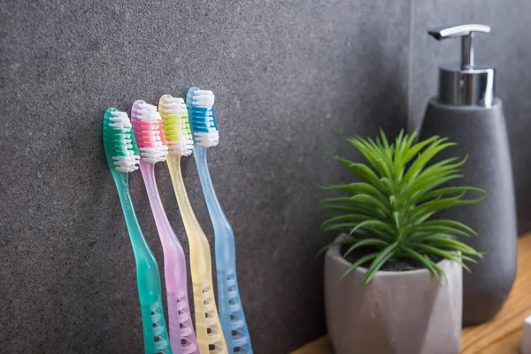 Banyoda arka planda aile için dört renkli diş fırçası. Hijyen ve ağız boşluğunun bakımı.