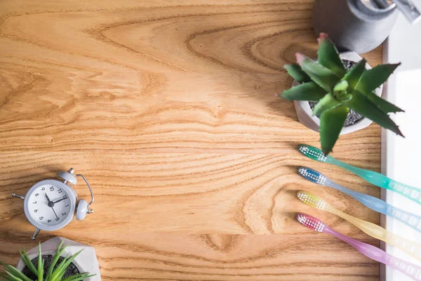 Χρωματιστά Οδοντόβουρτσα Γκρι Ρολόι Ξύλινο Τραπέζι Στοματική Υγιεινή Έννοια Της — Φωτογραφία Αρχείου