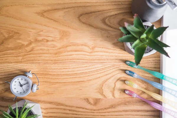 Gekleurde Tandenborstels Met Grijze Klok Een Houten Tafel Mondhygiëne Concept — Stockfoto