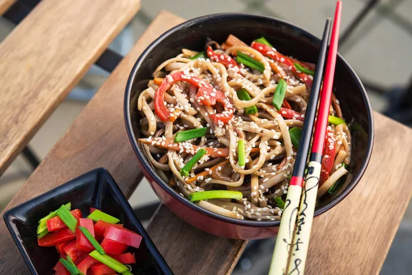 Masanın üzerinde sebzeli Tayland eriştesi. Asya fast food sokağı.