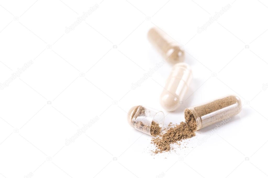 Health herbal medical capsule isolated on a white background. Open pills with powder.