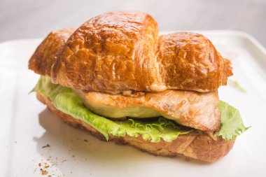 Beyaz tabakta et ve peynirli lezzetli kruvasan yakın plan. Taze ve lezzetli kahvaltı..