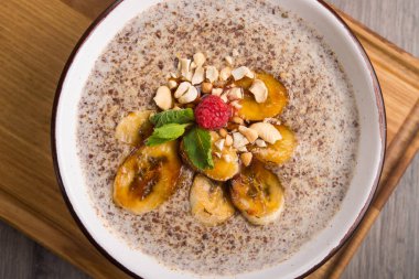 Tahta tahtada fındıklı yulaf ezmesi ve karamelli muz. Sağlıklı kahvaltı. en üstteki görünüm