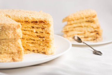 Beyaz masa örtüsü üzerinde tatlı Napolyon pastası. Tatlı yemek..