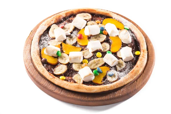 Sweet dessert pizza with chocolate, colored candy, banana and marshmallow isolated on white