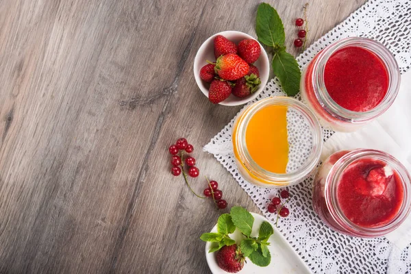 Lezzetli meyve reçeli ve ahşap bir masada böğürtlen. Tatlı ev yapımı tatlı geçmişi.
