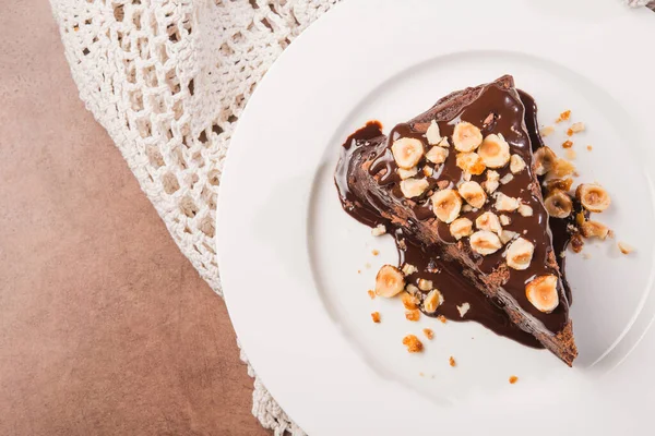 Beyaz tabakta fındıklı lezzetli çikolatalı pasta dilimi