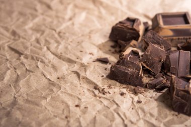 Kağıt üzerinde lezzetli siyah çikolata parçaları var. Boşluğu kopyala