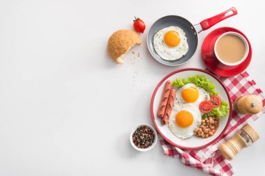 İngiliz kahvaltısı, kızarmış yumurta, fasulye, domates, sosis, taze marul yaprağı, kahve fincanı. Kırmızı yemek kavramı. Üst Manzara. Düz yatıyordu.