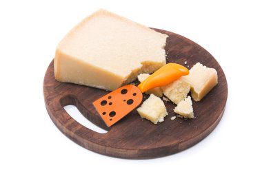 Beyaz arka planda izole edilmiş tahta kesim tahtasındaki parmesan peyniri parçaları.