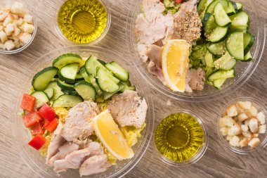 Ahşap zemin üzerinde taze salata olan plastik paket kutusu. Üst görünüm.