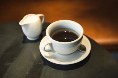 Siyah metal bir kafe masasında beyaz espresso fincanı.