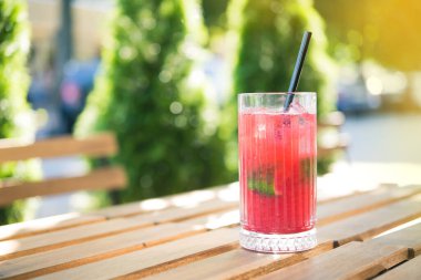 Soğuk yaz ferahlatıcı bir kokteyl, açık kafedeki ahşap bir masada.