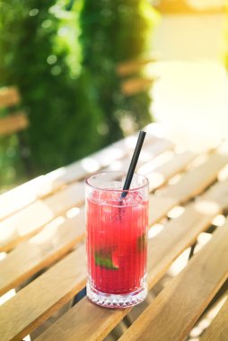 Soğuk yaz ferahlatıcı bir kokteyl, açık kafedeki ahşap bir masada.