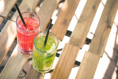 Soğuk yaz ferahlatıcı kokteyl ahududu ve limon, açık kafedeki ahşap masada kivi. Metin için boşluk.