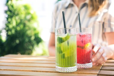 Genç ve güzel bir kız kafedeki ahşap masada soğuk içecek kokteyli içiyor. Yaz yaşam tarzı insanları.