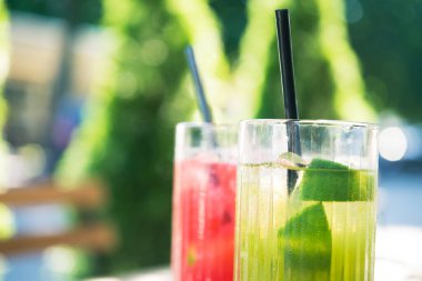 Soğuk yaz ferahlatıcı kokteyl ahududu ve limon, açık kafedeki ahşap masada kivi.