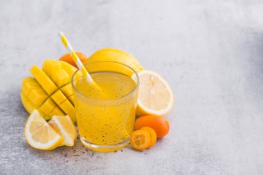 Diyet detoks içeceği, chia tohumu, mango, limon ve kumkuat meyveleri ile taş bir masada. Taze egzotik içecek. Boşluğu kopyala.
