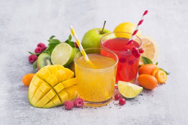 Çiğ taneleri, mango, limon, ahududu, frenk üzümü ve kumkuat meyveli tropikal detoks içecekleri. Taze, egzotik yaz içeceği..