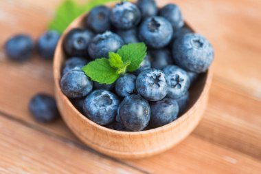 Tahta bir masada naneli taze ve doğal yaban mersini. Böğürtlen organik, vitamin yiyecekleri.