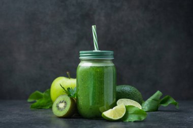 Ispanak, kivi, ıhlamur ve avokado karışımından yapılmış cam kavanozda yeşil detoks smoothie. Diyet ve vitaminli içecek..