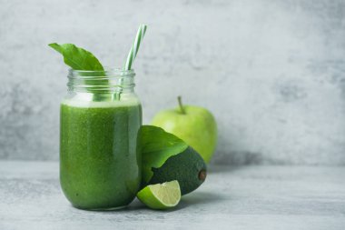 Yeşil detoks smoothie cam kavanozda ıspanak, kivi, limon, avokado hafif taşlı arka planda. Diyet ve vitamin meyveli sağlıklı içecek, vejetaryen gıda konsepti. Boşluğu kopyala