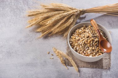 Taş bir masada tohum ve buğdaylı kâse içinde lezzetli gevrek tanecikler. Sağlıklı kahvaltılık mısır gevreği. metin için boşluk kopyala