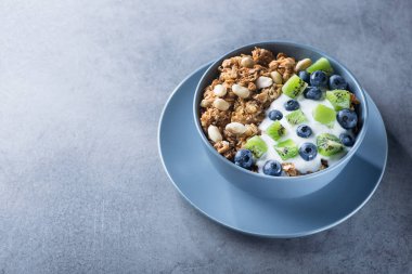 Mısır gevreğiyle sağlıklı kahvaltı yabanmersinli, kivili, yoğurtlu ve mavi kasede yer fıstıklı. Günaydın tatlı tatlı atıştırmalık.