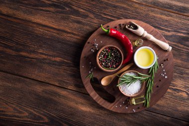 Tuz, karabiber, biberiye dalı ahşap masa üzerinde kırmızı acı biber. Üst Manzara. metin için boşluk kopyala