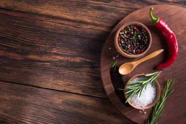 Tuz, karabiber, biberiye dalı ahşap masa üzerinde kırmızı acı biber. Üst Manzara. metin için boşluk kopyala