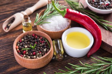Tuz, karabiber, biberiye dalı, tahta kesme masasında kırmızı acı biber..